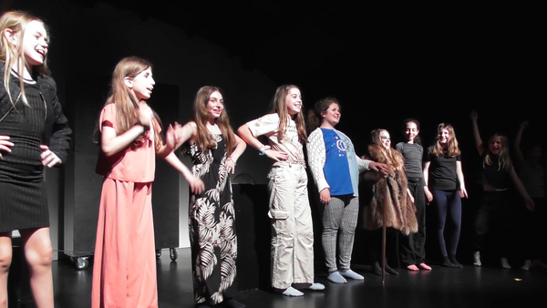Kinder stehen am Ende eines Theaterstückes in einer Reihe auf einer Bühne für die Verbeugung